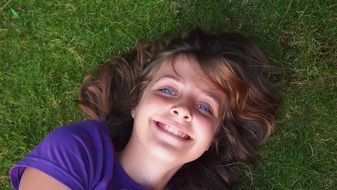 cheerful young girl on the lawn in the garden