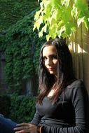 photo of a girl with black hair at the hedge