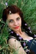 girl with braided flowers into her hair on the background of the summer field