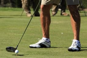 a man with a club plays golf on a field