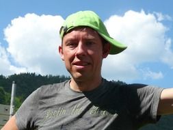 man in a green plate cap in the bright sun