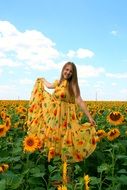 girl in a dress on a background of a field of sunflowers