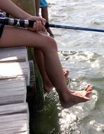 legs of fishing kids above water
