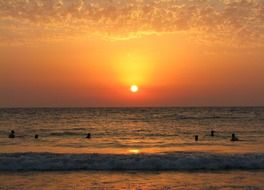 people swim at sunset