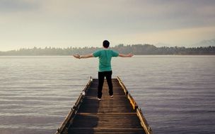 Man with wide open hands on the pier