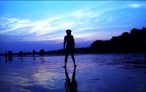 silhouettes of people on the beach on the background of horizon