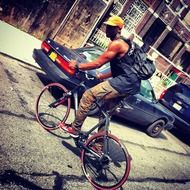 young man is riding a bicycle on city streets