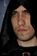 a man with an expressive look in a black hood
