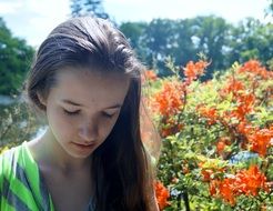 girl with long hair on the background of a blooming garden