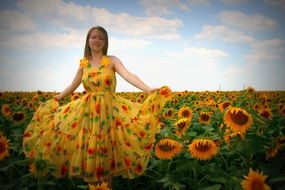 Girl in a lush yellow dress against the backdrop of a field of sunflowers