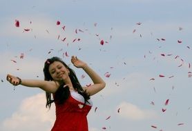 Girl in the petals against the sky