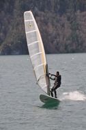 man on a surfboard with a sail