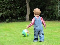 Child is playing football in the garden