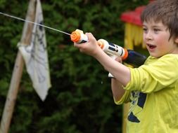 boy is playing with a water gun