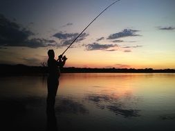 fishman in water sunset view