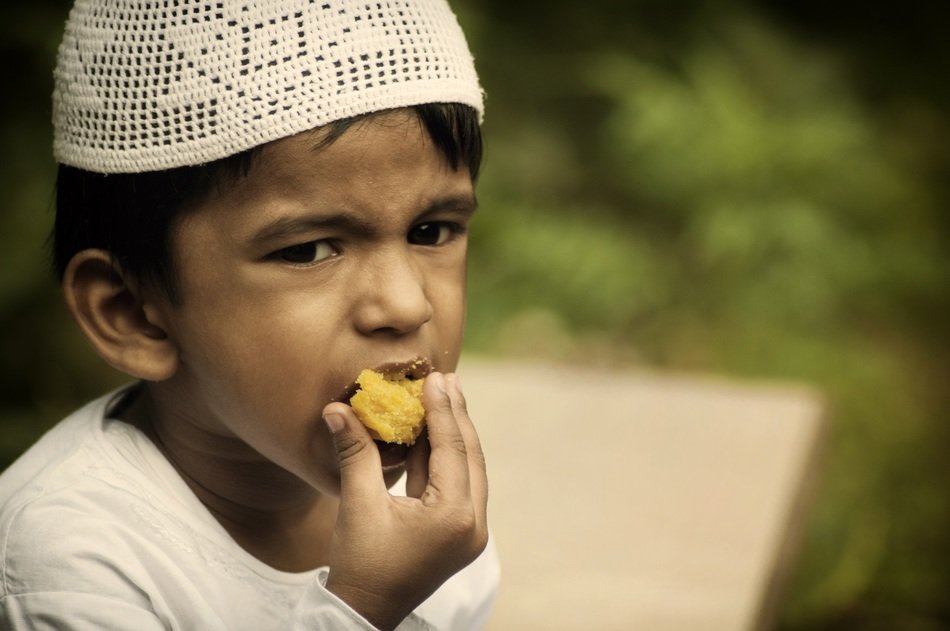 muslim boy is eating on ramadan holiday