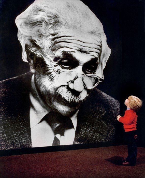 Young bou looking at albert einstein portrait