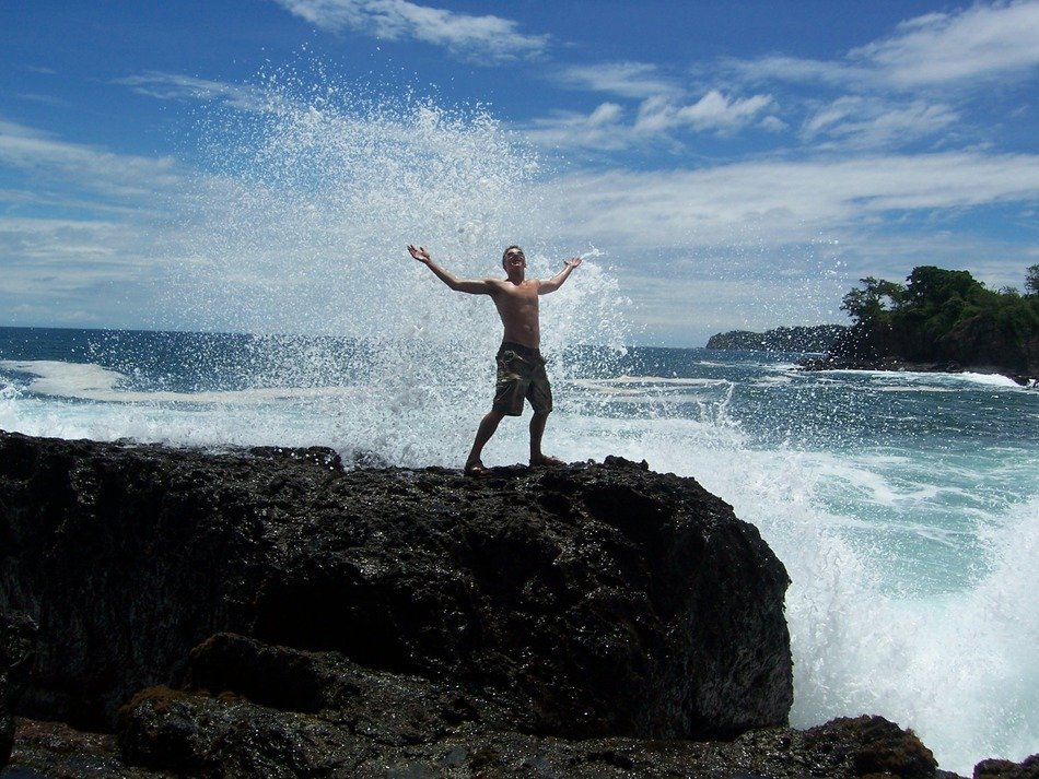 photo of a young man in the spray of the ocean