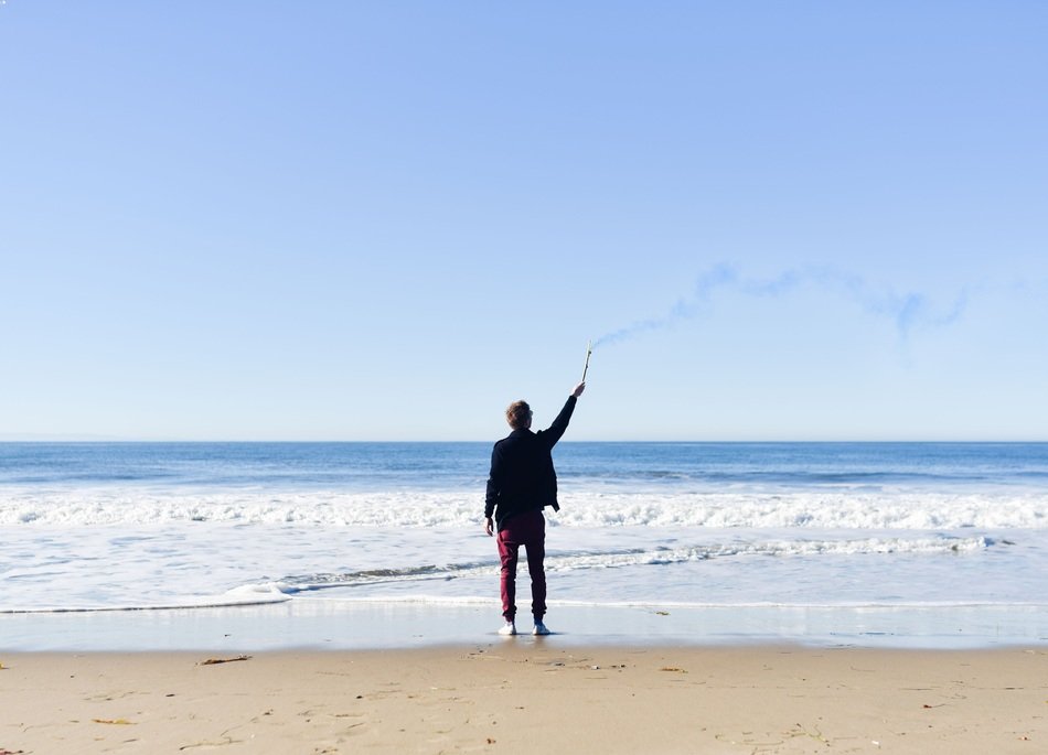 man on the beach with smoke signal