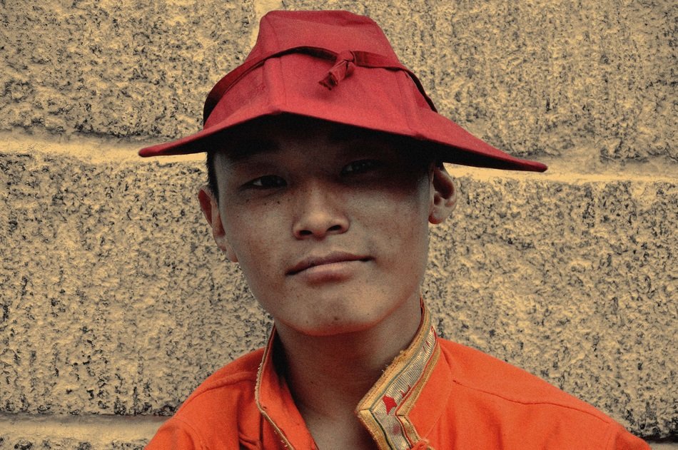 tibetian man in red hat at the wall background