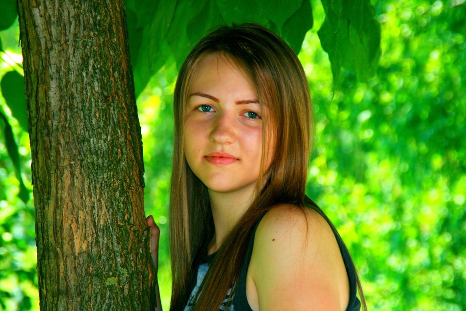 portrait of a girl with blond hair on a background of tree