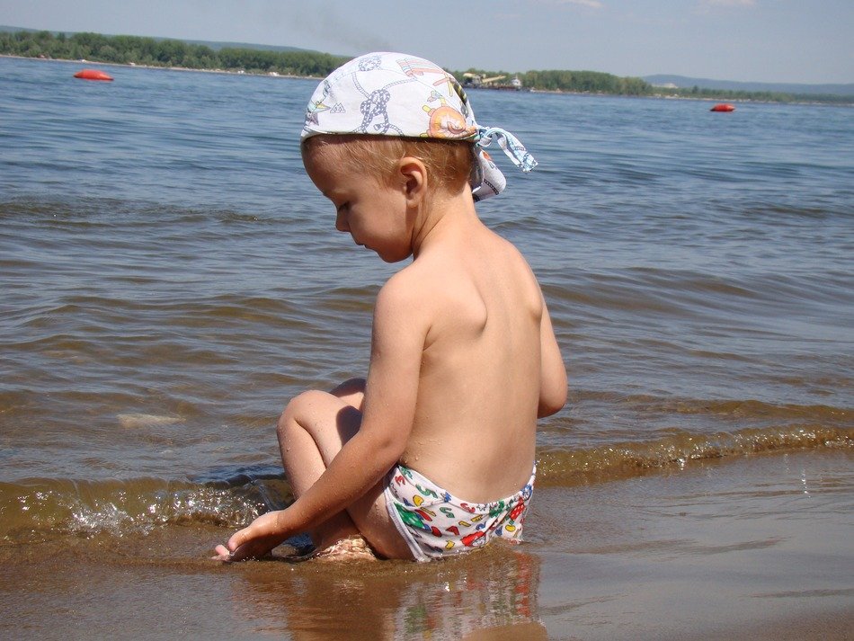 the child sitting plays on the water