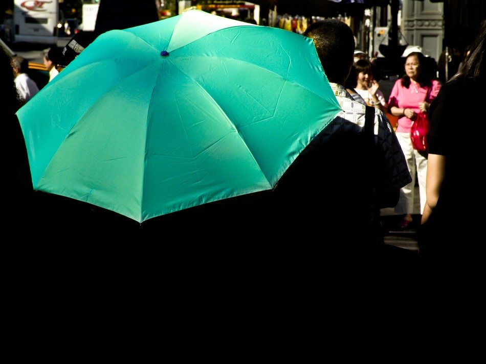 bright green umbrella on busy street