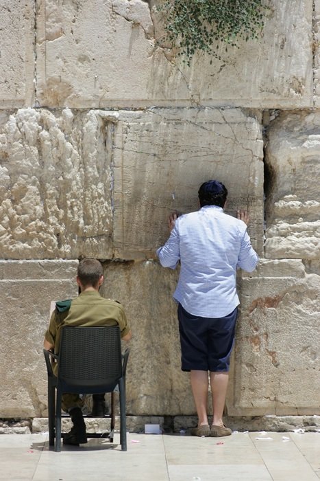 back view of people praying at the Western Wall (Wailing Wall)