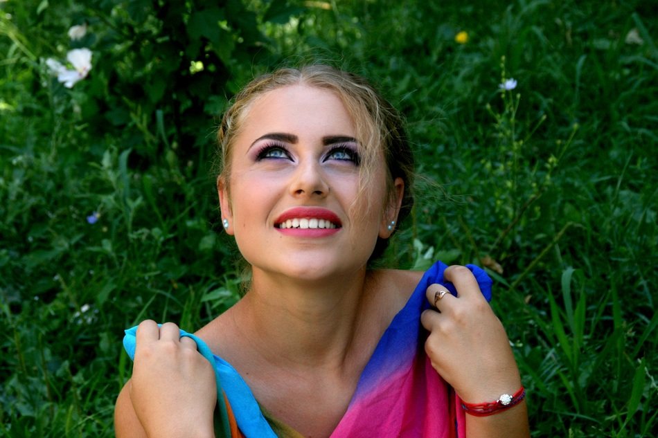 attractive girl with colored cloth in her hands looking up