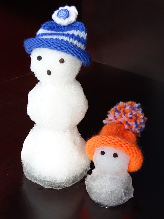 two snow men in caps