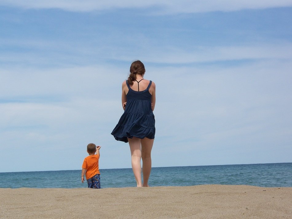 child and girl go on the beach
