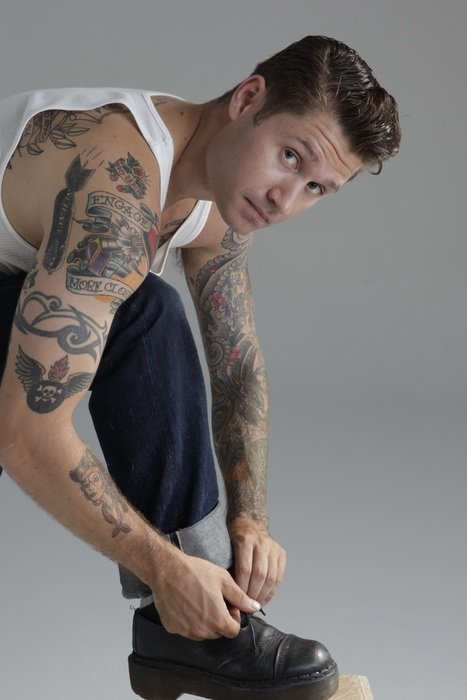 the tattooed man ties his shoelaces
