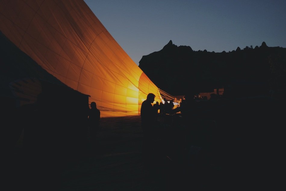 silhouettes of people near the hot air balloon at night