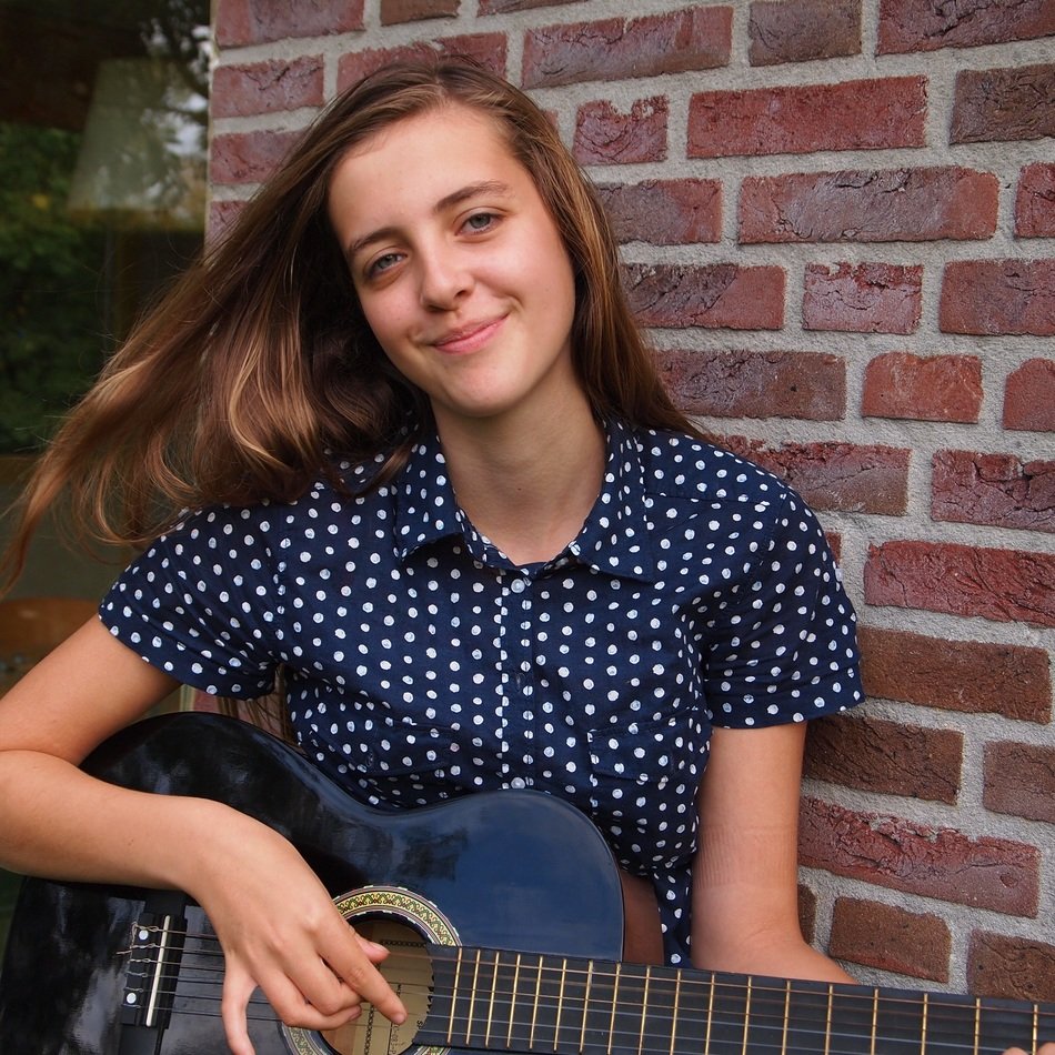 positive young girl with a guitar in his hands