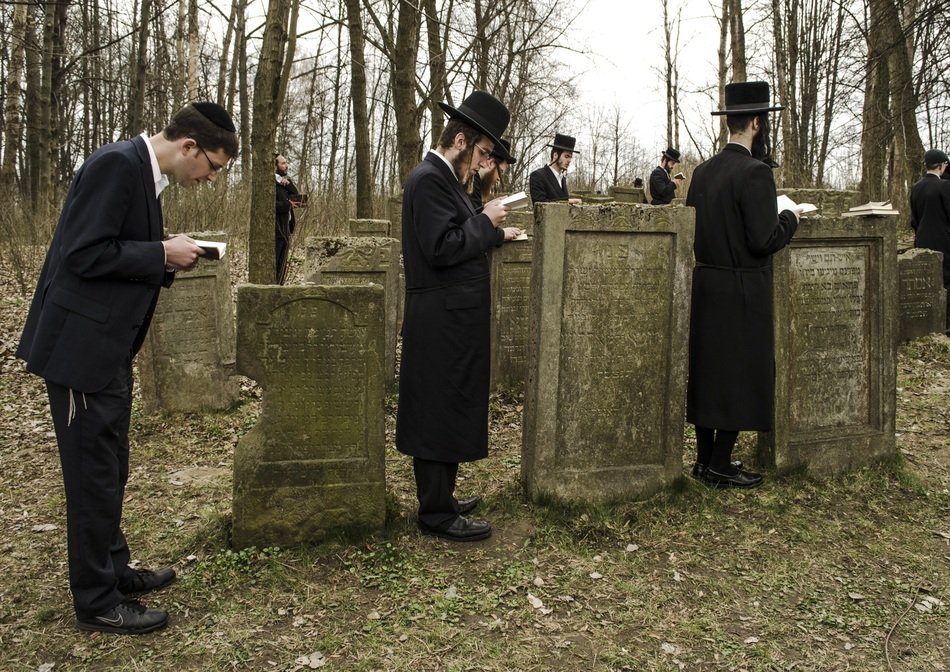 jews praying on cemetery at gravestones