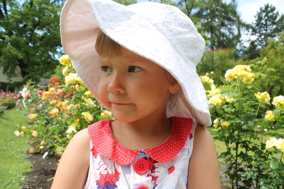 girl in white panama in the blooming garden