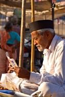 portrait of indian old man reading newspaper