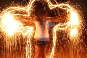 figure of a girl in the light of sparklers at night