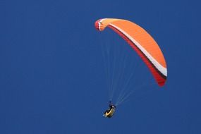 color glider flies in blue clear sky