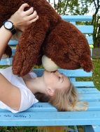 girl kissing a toy bear