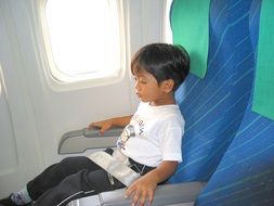 asian boy in airplane seat