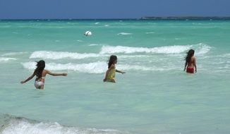 children playing in the blue water of the sea