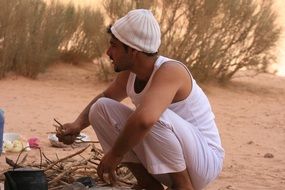 man making meals on a wood fire