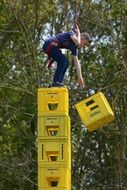 child boy playing at top of stack of boxes