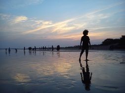 silhouette of a boy on the evening beach