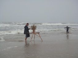 artist draws on the beach