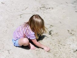 photo of a girl playing in the sand