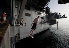 sailor jumps from a ship into the water