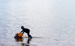 boy playing with a machine on the lake beach