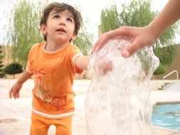 the child touches the water at the fountain